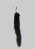 Black Gamma mink tail chrome topped keyring by Stacy Stewart Smith on an antique white surface