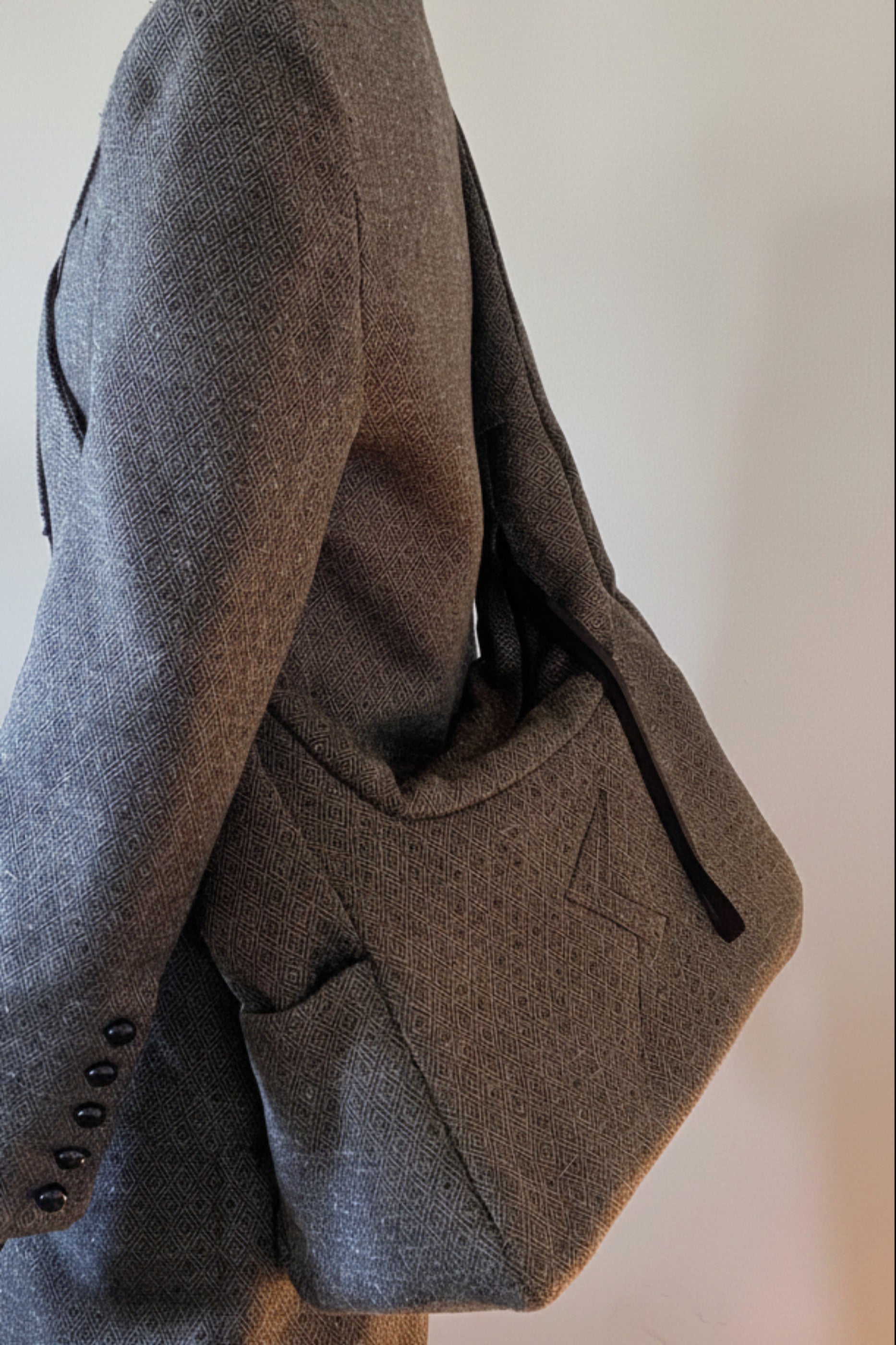 Stacy Stewart Smith's Men's Diamond Dodger Trapezoid messenger bag in Cement/Onyx 3/4 view on a mannequin  6'3" against a gray background.