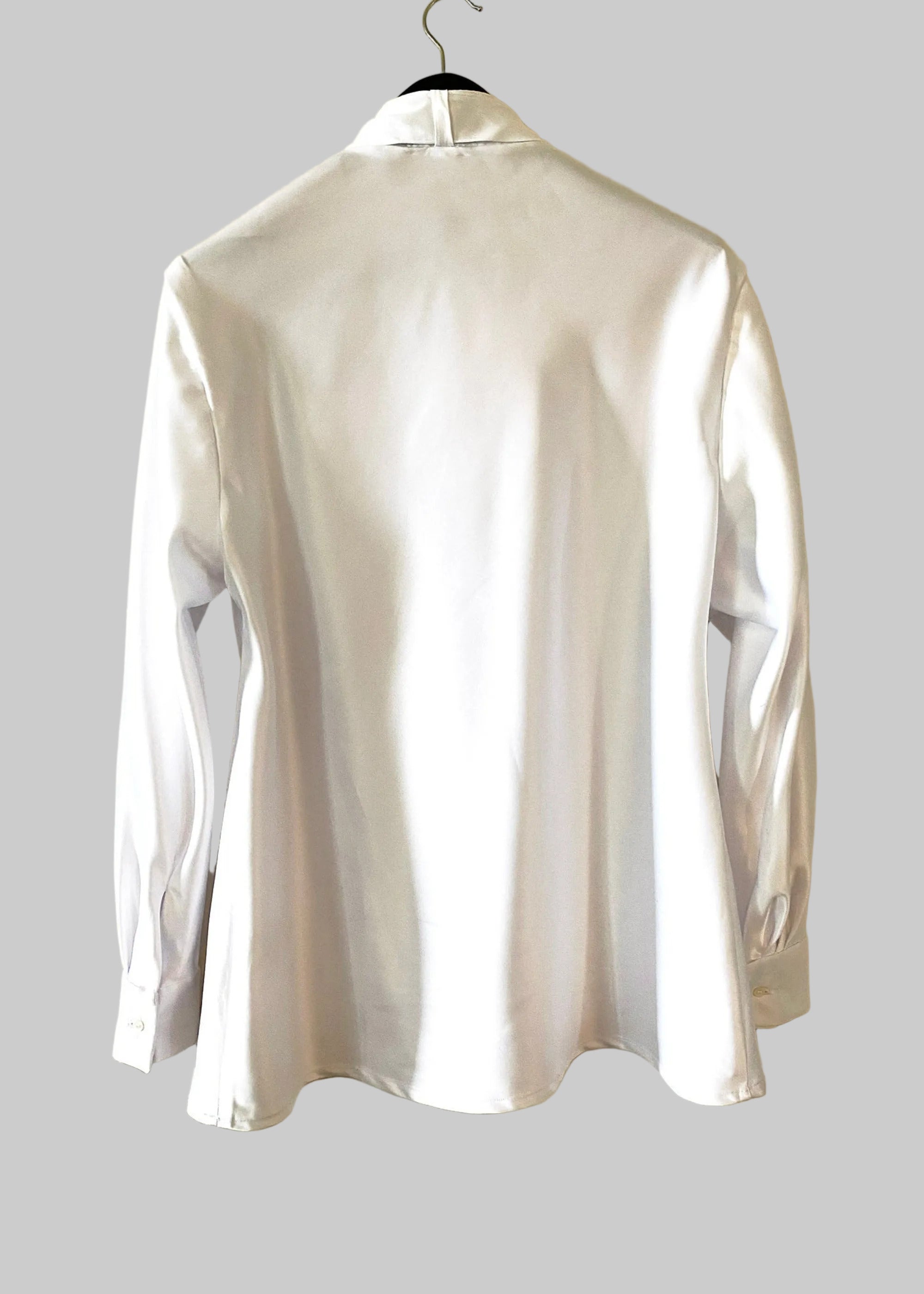 Stacy Stewart Smith Men's Noble Innocent Satin Shirt on a hanger back view against antique white wall.