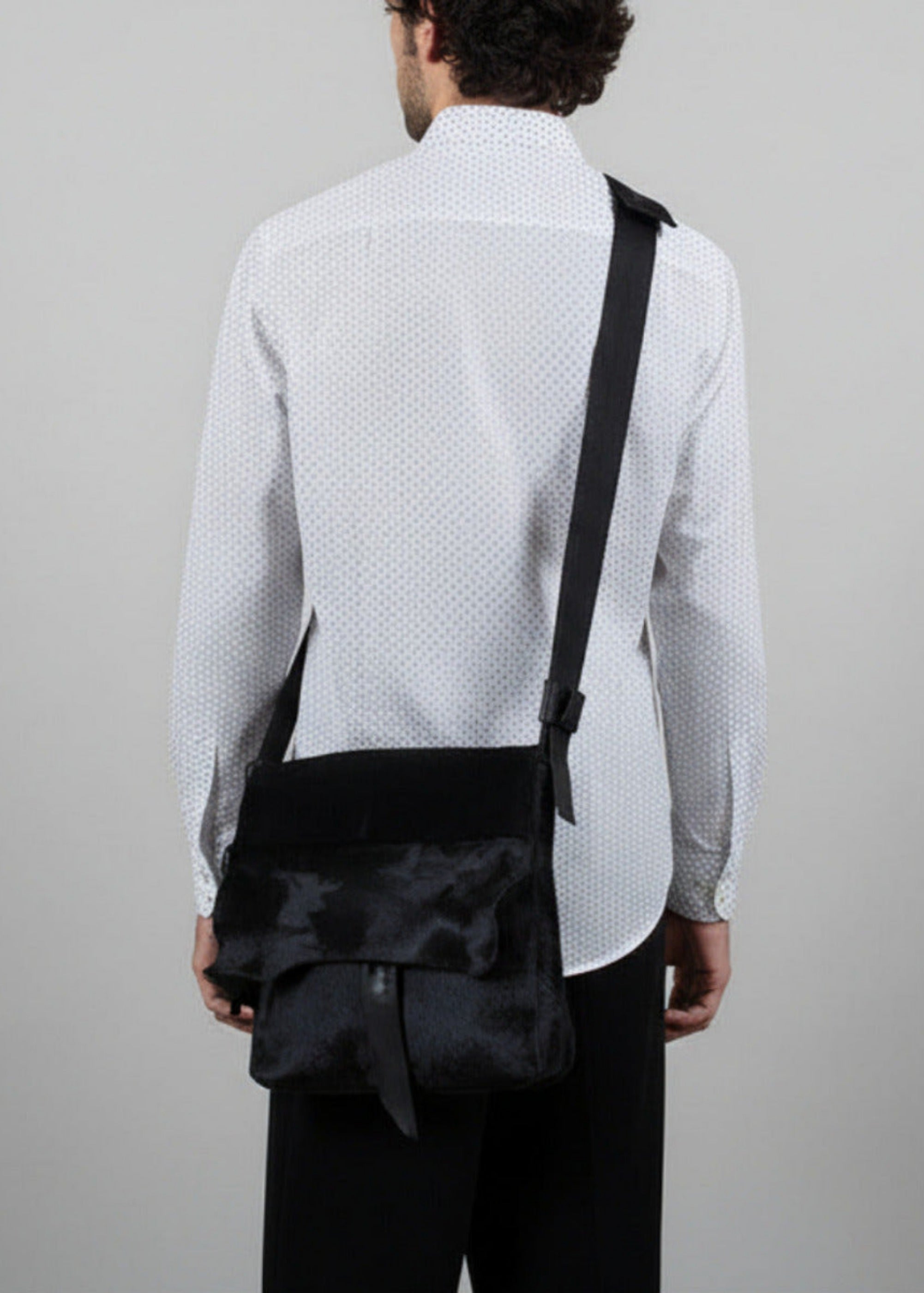 Stacy Stewart Smith Hair-On Calf Powder Satchel Bag on mannequin 6'3" wearing hand painted white and silver dot shirt by the designer back view gray background. 
