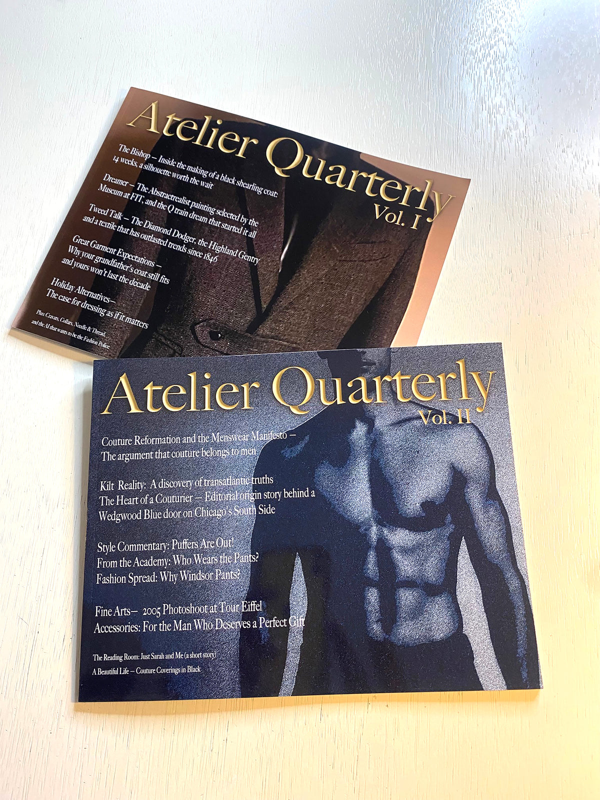 Two printed magazine or booklets titled "Atelier Quarterly Vol. 1" and "Atelier Quarterly Vol.