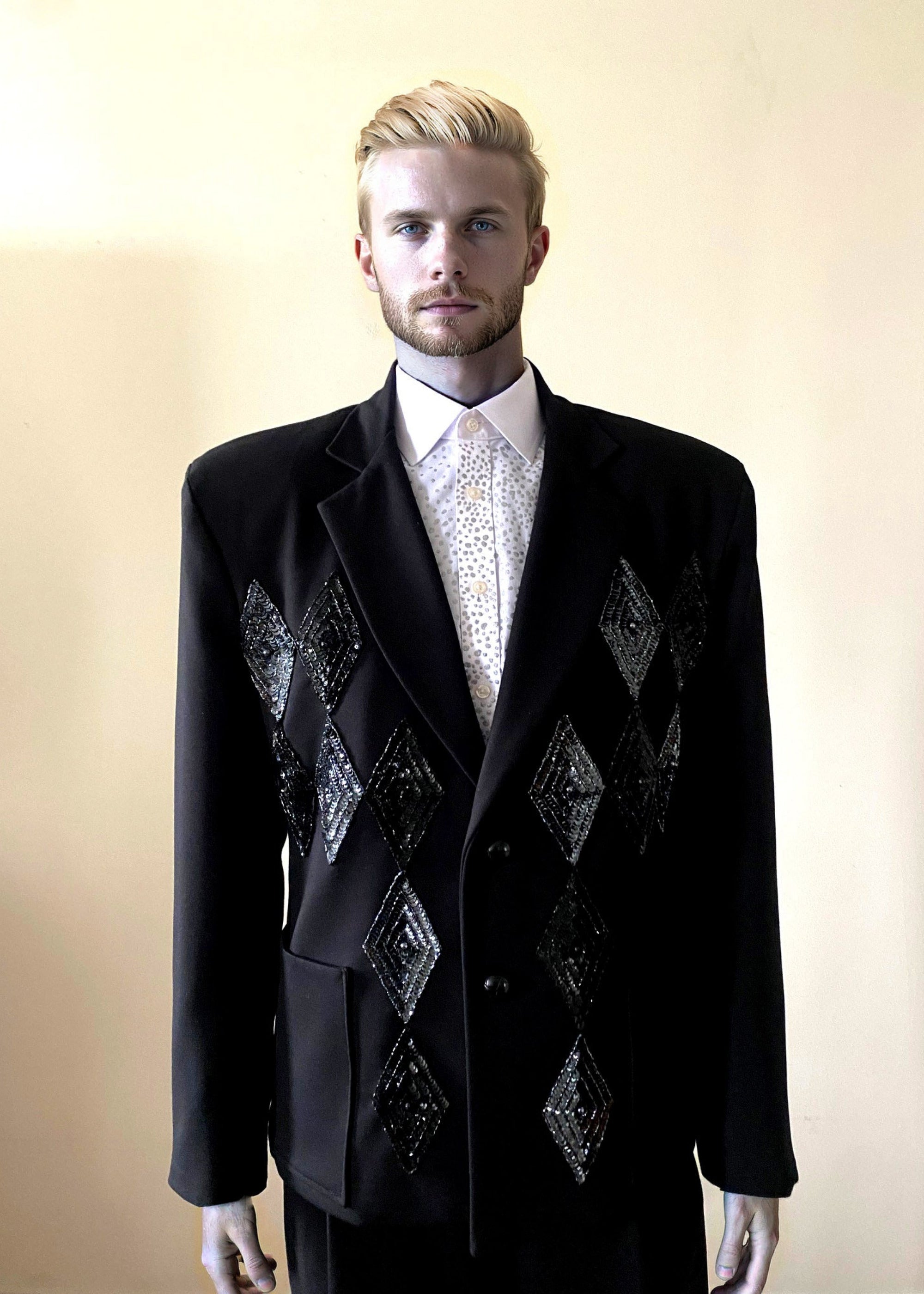 Stacy Stewart Smith Men's Black Knit, Sequin and Beaded Harlequin Blazer on mannequin 6'3" front view against antique white wall.