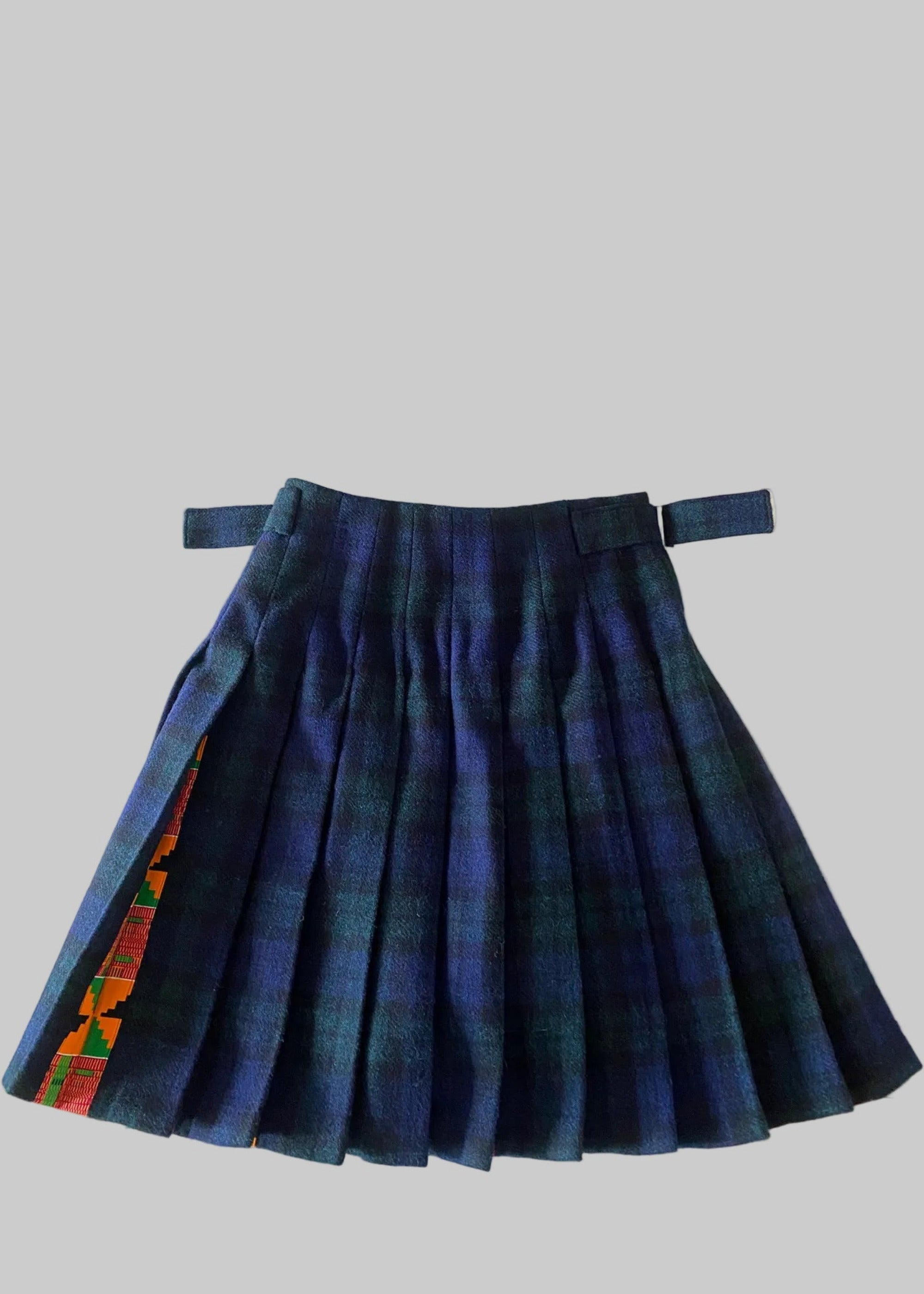 Stacy  Stewart Smith men's Harris Tweed© Blackwatch in blue and green tones Plaid reality Kilt has Kente cloth inlays, chrome side adjustable buckles back flat view against a plain light surface.