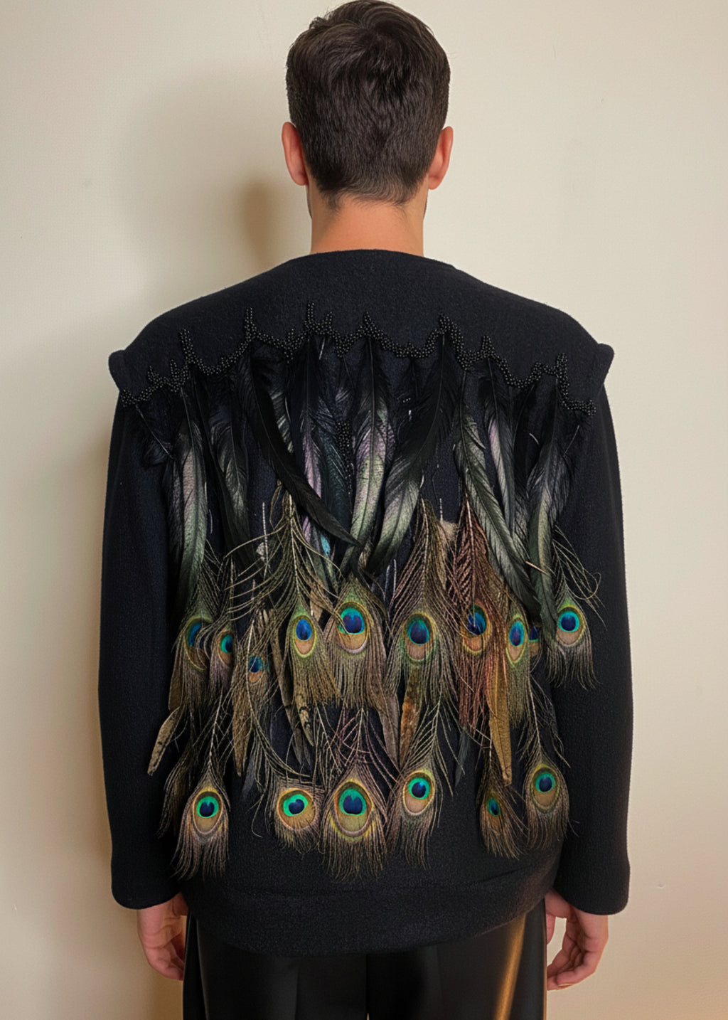 Stacy Stewart Smith Men's Pennaceous Beaded Black Boiled Wool Sweater with peacock, quail and rooster feathers back view  against an ivory backdrop. 