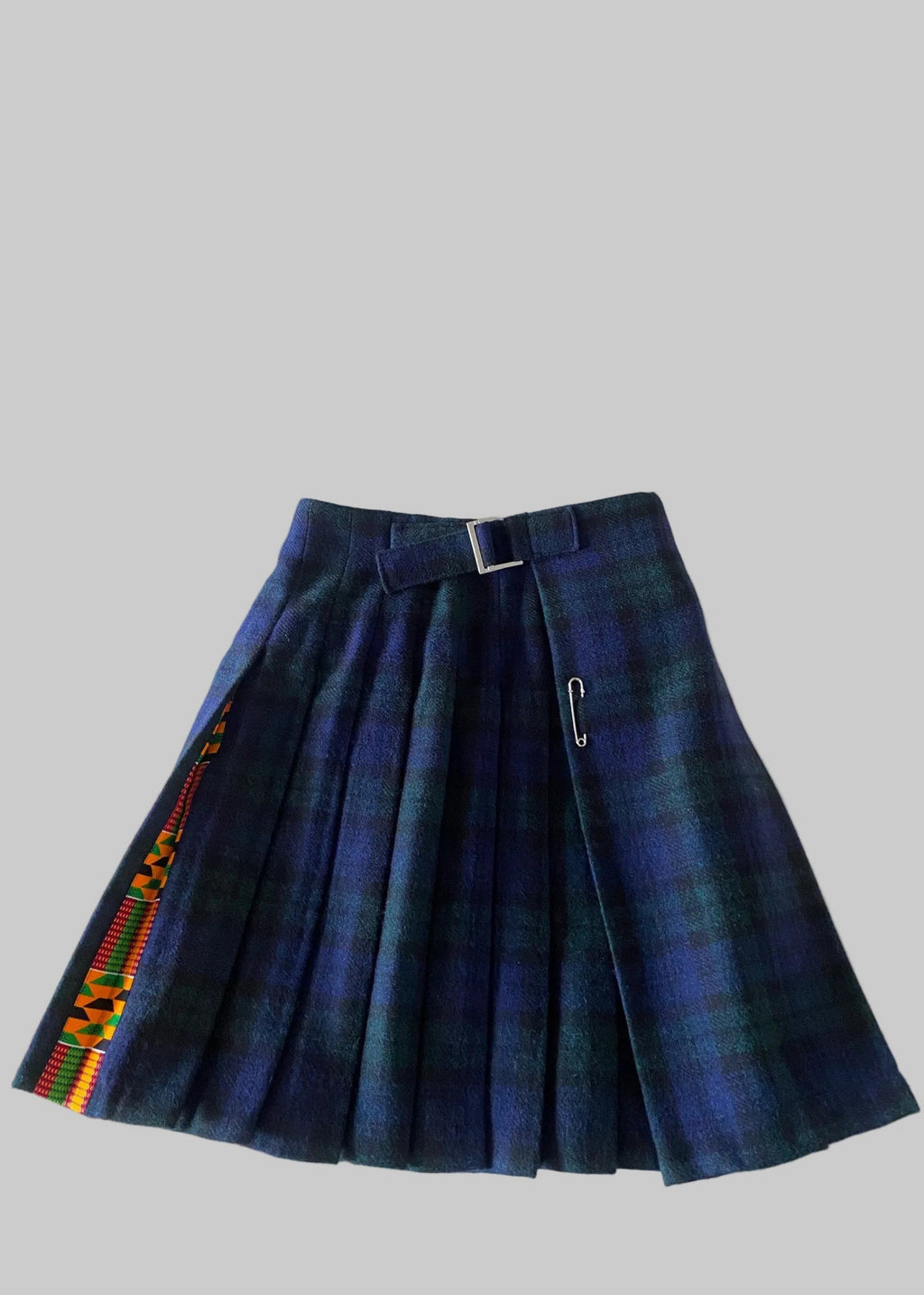 Stacy  Stewart Smith men's Harris Tweed© Blackwatch in blue and green tones Plaid reality Kilt has Kente cloth inlays, chrome side adjustable buckles side flat view against a plain light surface.