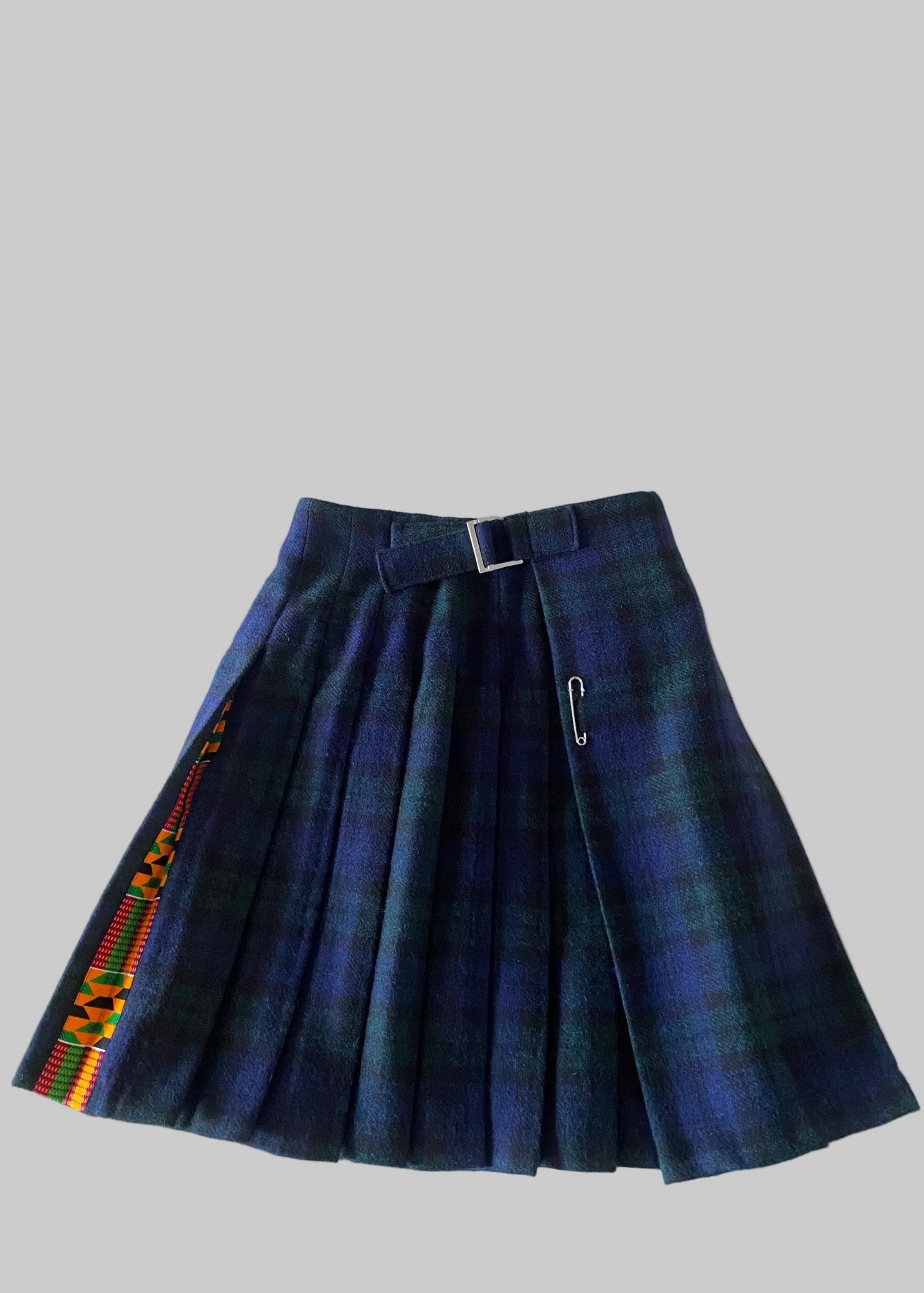 Stacy  Stewart Smith men's Harris Tweed© Blackwatch in blue and green tones Plaid reality Kilt has Kente cloth inlays, chrome side adjustable buckles side flat view against a plain light surface.