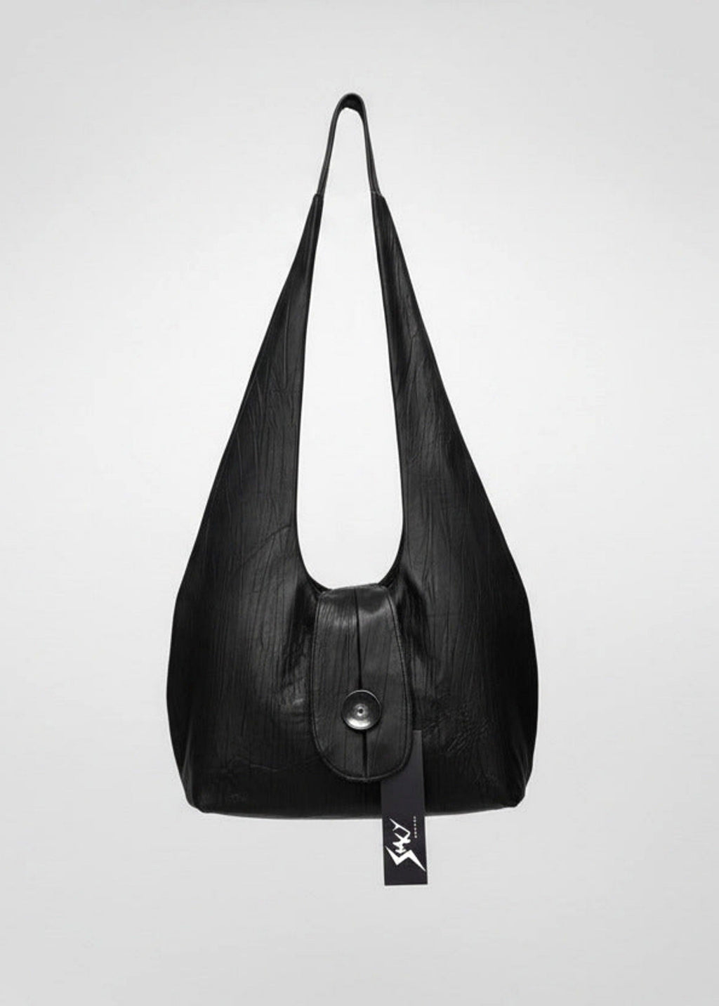 Stacy Stewart Smith Euclidian Space Crinkled Leather Messenger Bag frontal view floating frontal view with tongue flap and brand hang tag in front of a gray backdrop.