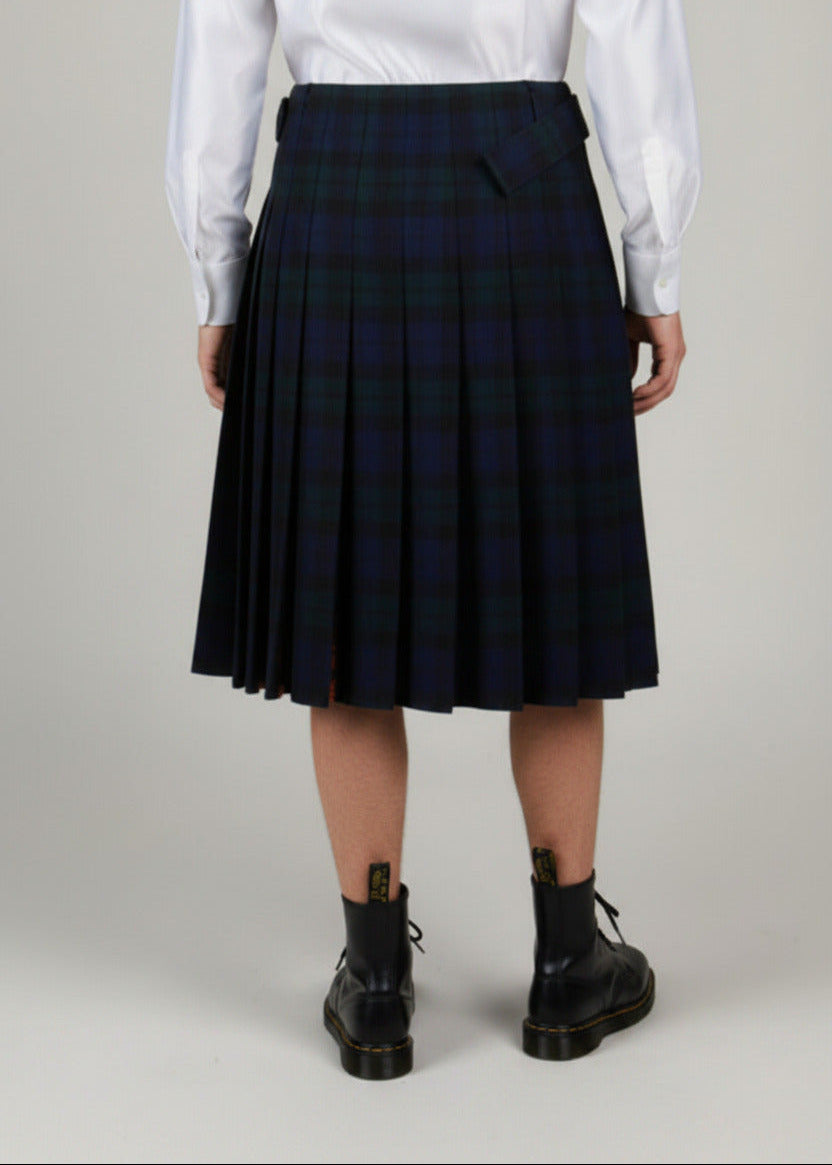 Stacy  Stewart Smith men's Harris Tweed© Blackwatch in blue and green tones Plaid reality Kilt has Kente cloth inlays, chrome side adjustable buckles on a mannequin 6'3" half back view against a plain light surface.