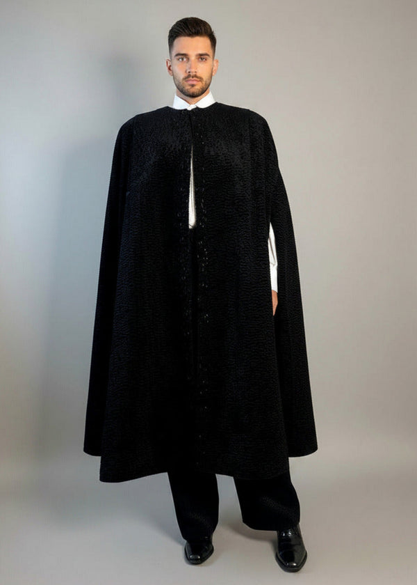 The Grand Soir Palace Cape by Stacy  Stewart Smith is cut for exactly that moment — a structured sweep of flowing black Persian lamb on a mannequin 6'3" against a gray backdrop. Front view with  cape slightly open to show bugle beading and one arm through front elbow slit.