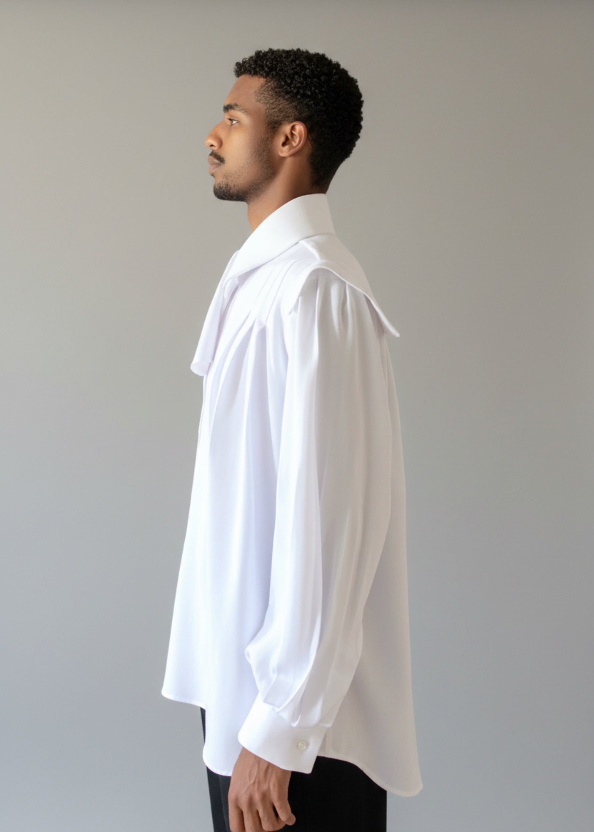 Stacy Stewart Smith Men's Poet Laureate White Silk Crepe Shirt on mannequin 6'3" side view with jabot-with black suede Windsor pants un-tucked against gray backdrop.