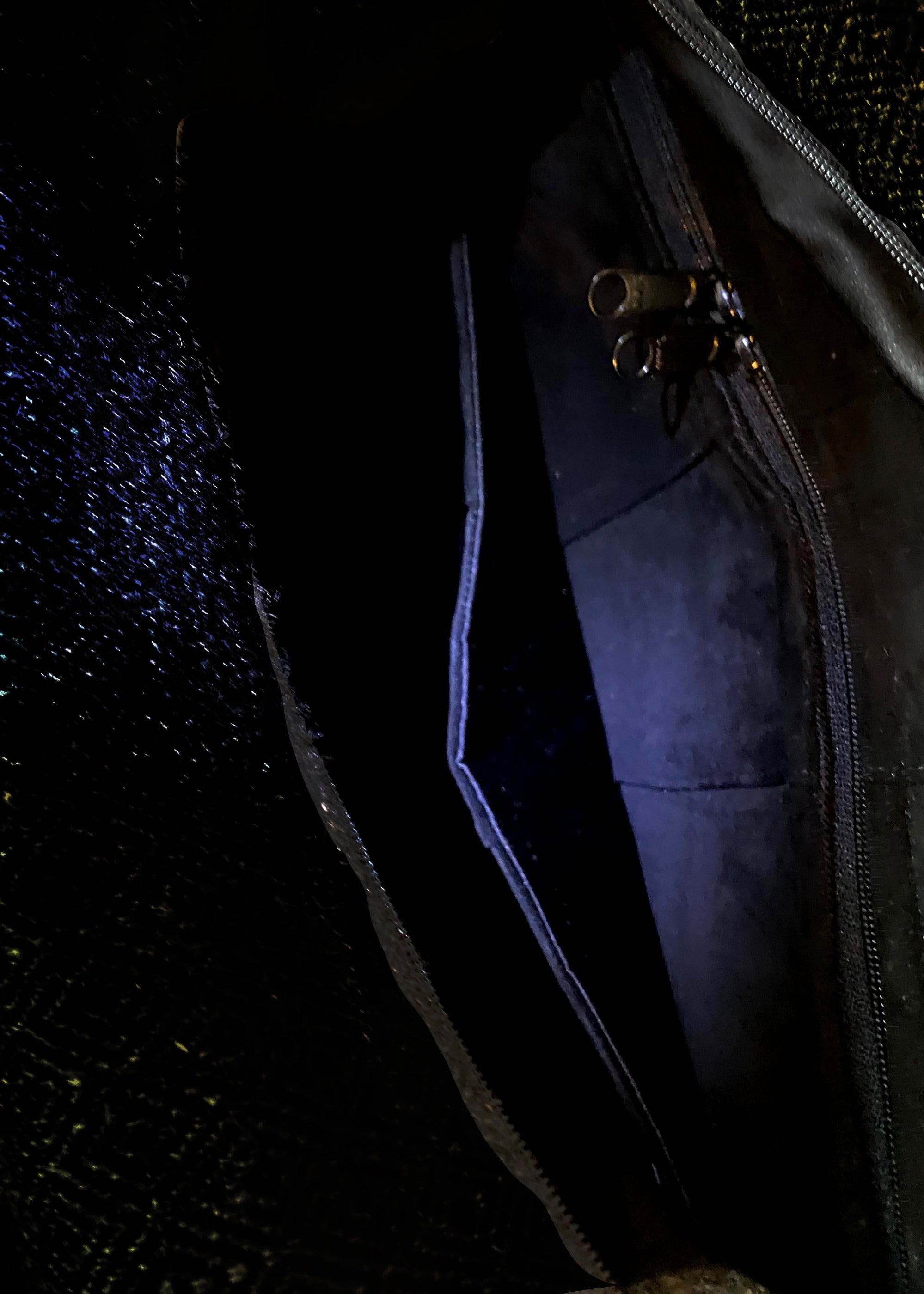 Stacy Stewart Smith's Men's Onyx Harris Tweed Trapezoid messenger bag in  inside onyx suede lining view showing zip pocket and divider against a gray background.