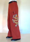 Stacy Stewart Smith Dragon & Ruby Flat Front Persimmon Cotton Twill Windsor Pants on a mannequin 6'3" left side 3/4 view.