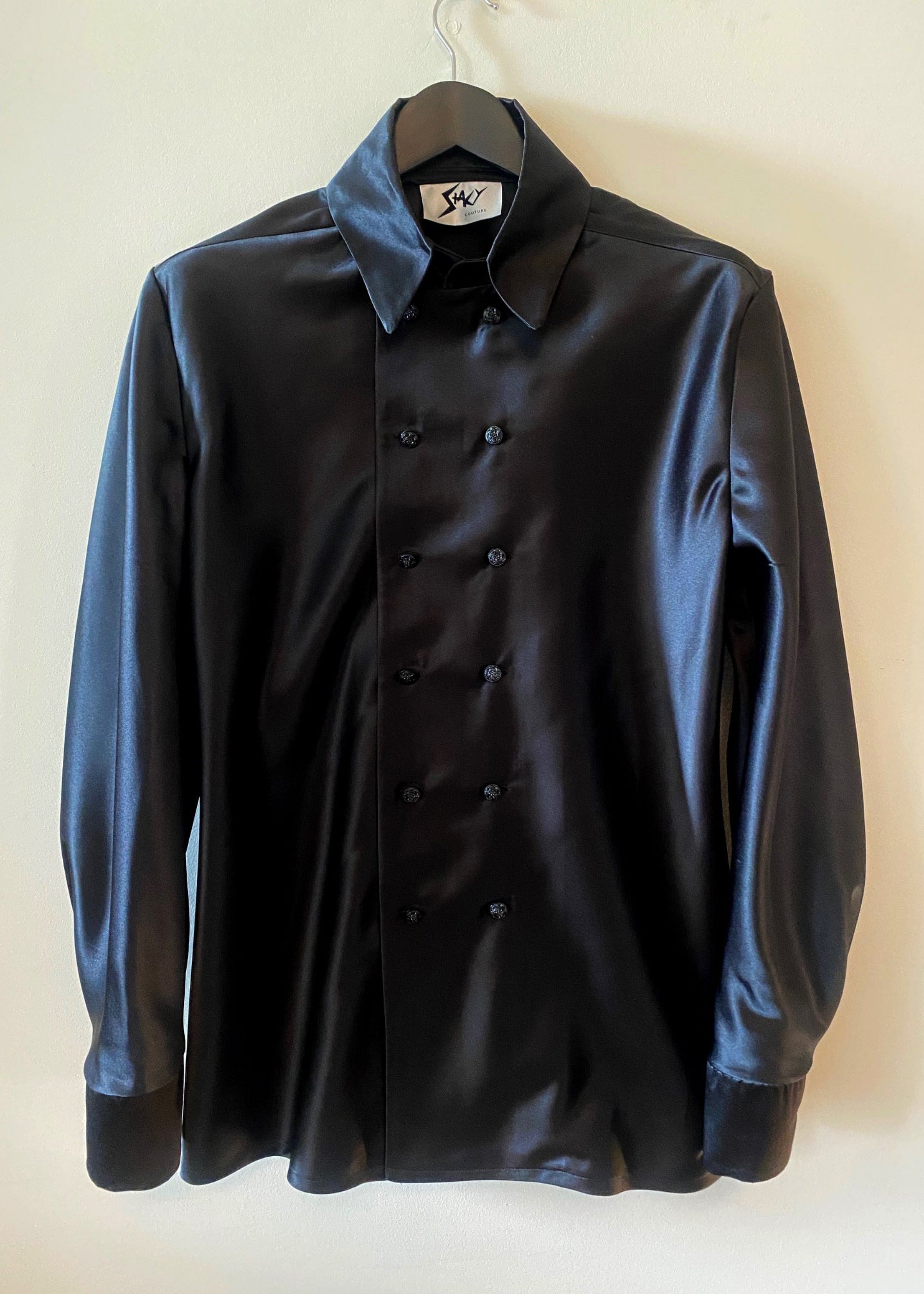 Stacy Stewart Smith Men's Onyx Duex Fois Silk Satin Shirt on a hanger frontal view hanging against an antique white wall.