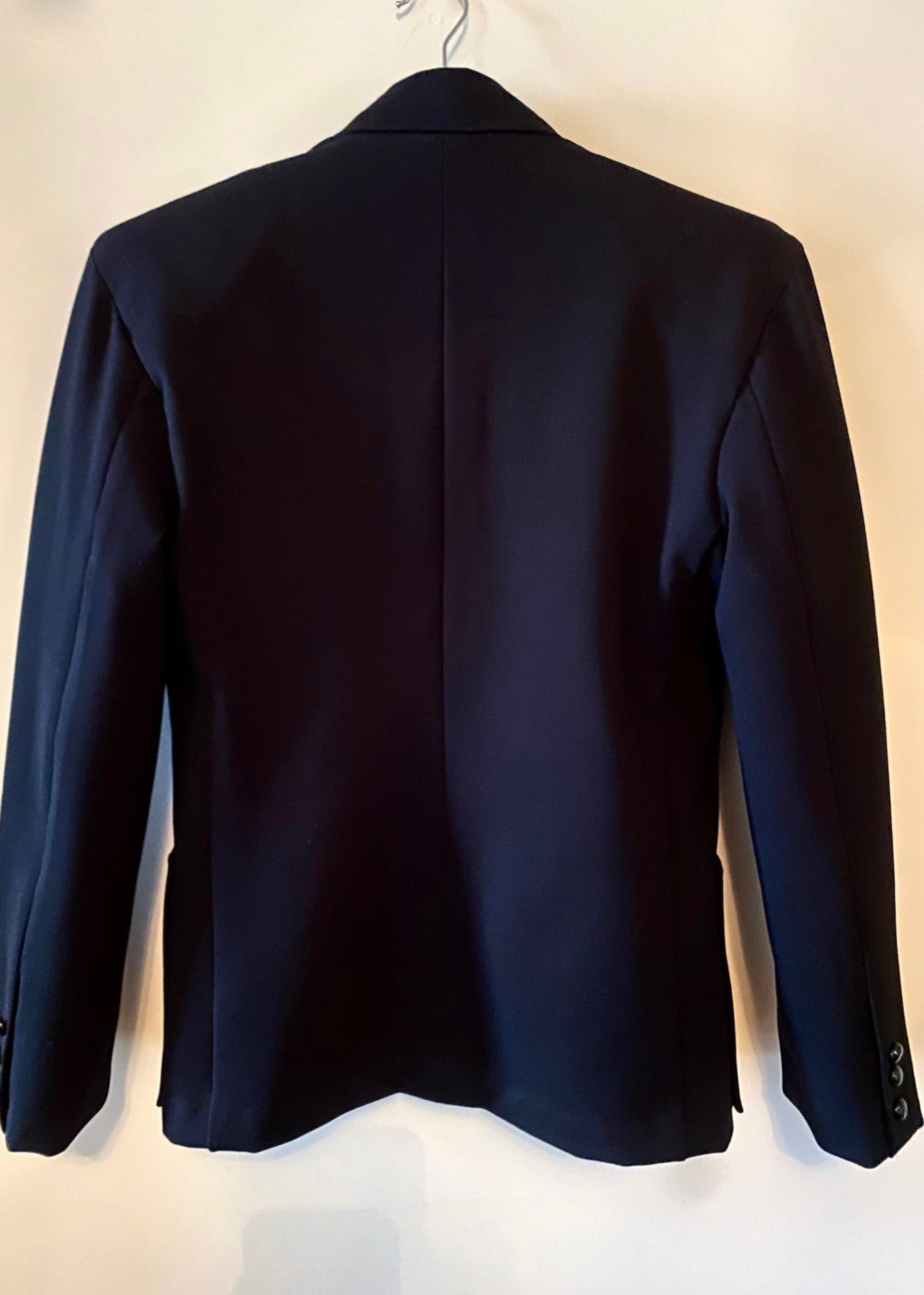 Stacy Stewart Smith Men's Black Knit, Sequin and Beaded Harlequin Blazer back view on a hanger with antique white wall.