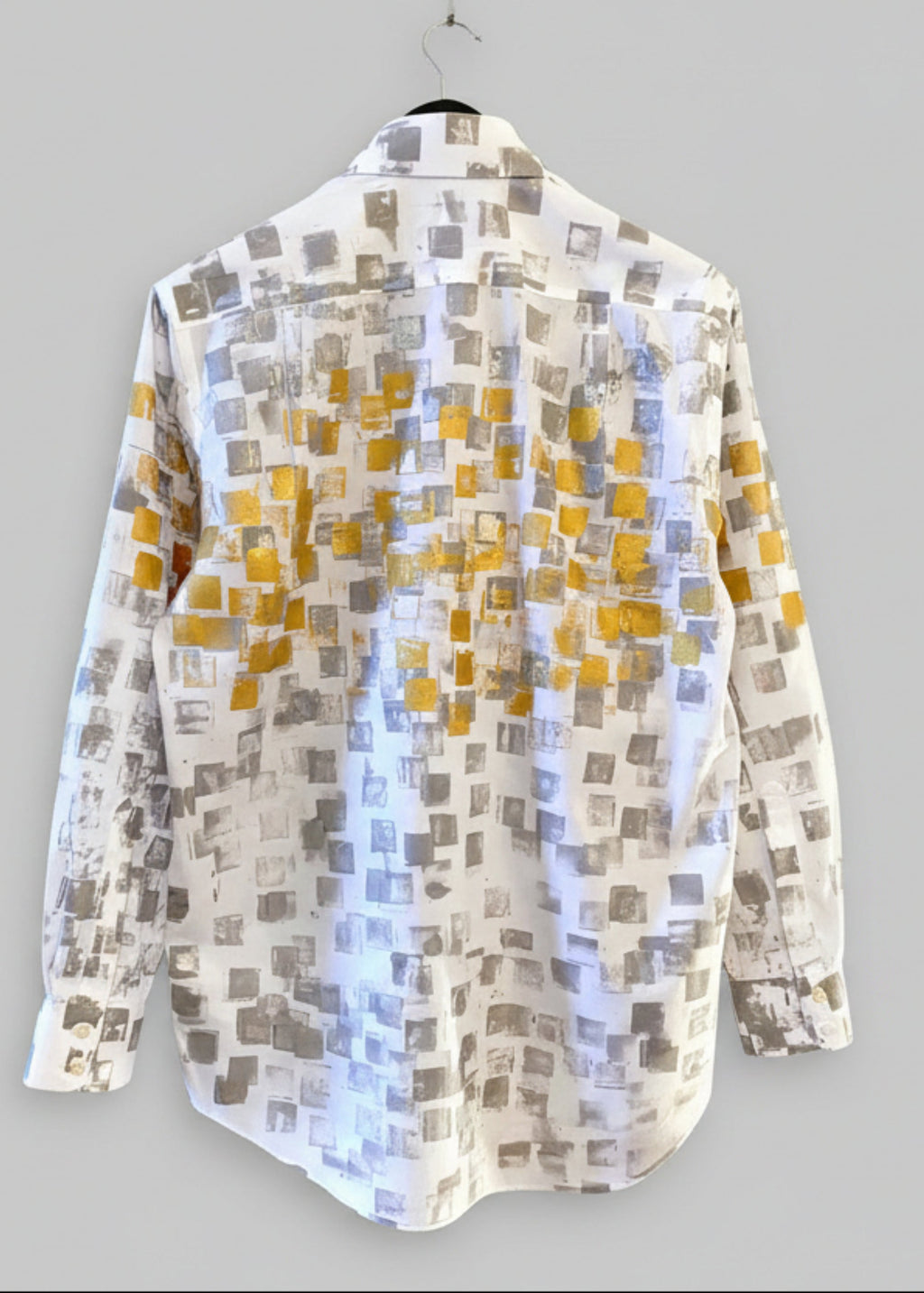 Stacy Stewart Smith Men's White Premium Cotton Percale Hand-Painted Gold & Silver Pixels Shirt back view on a hanger with gray background. 