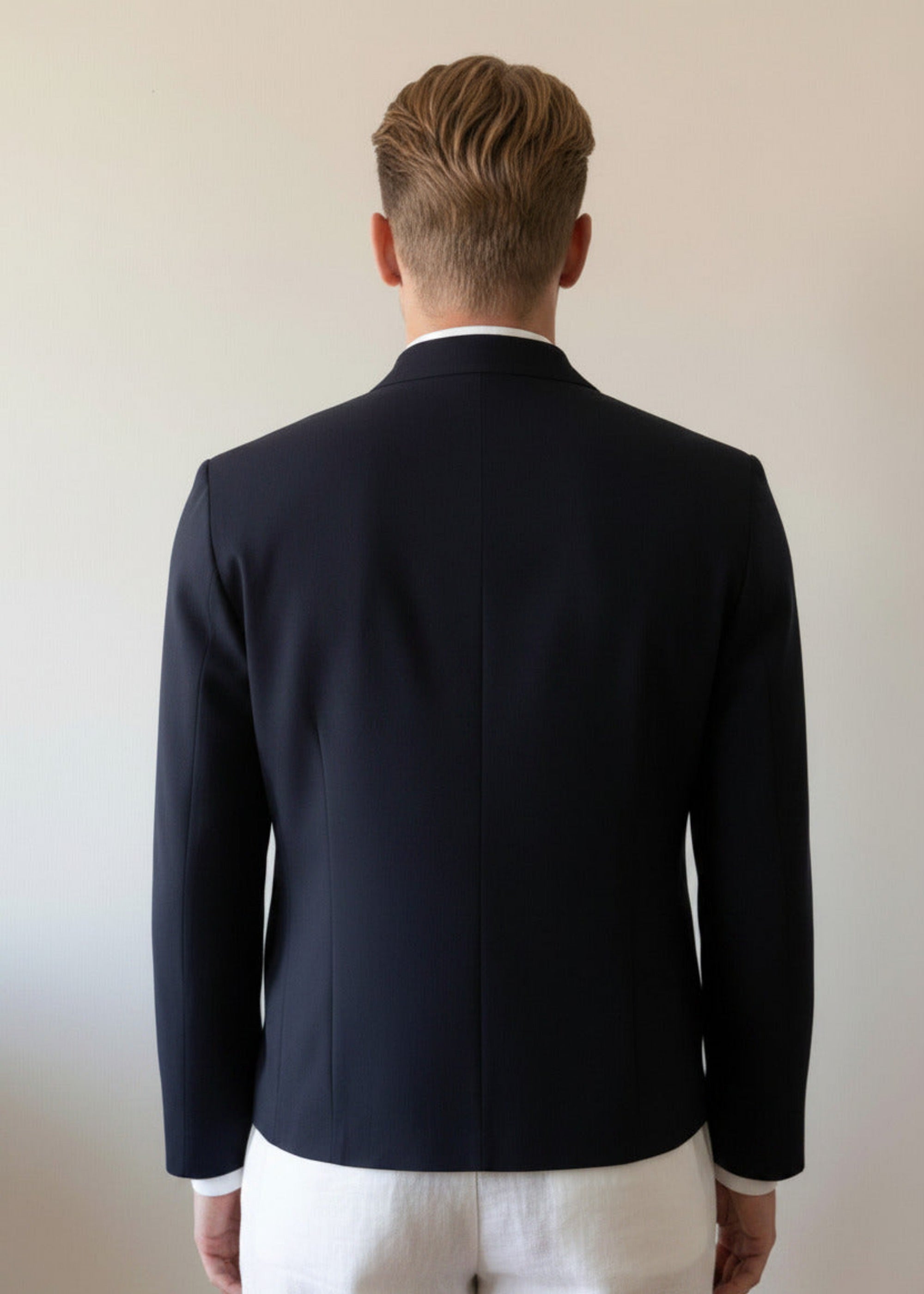Stacy Stewart Smith Men's black Python & Denim Bellhop Jacket on a glass mannequin 6'3" zoomed back view with antique white wall backdrop. 