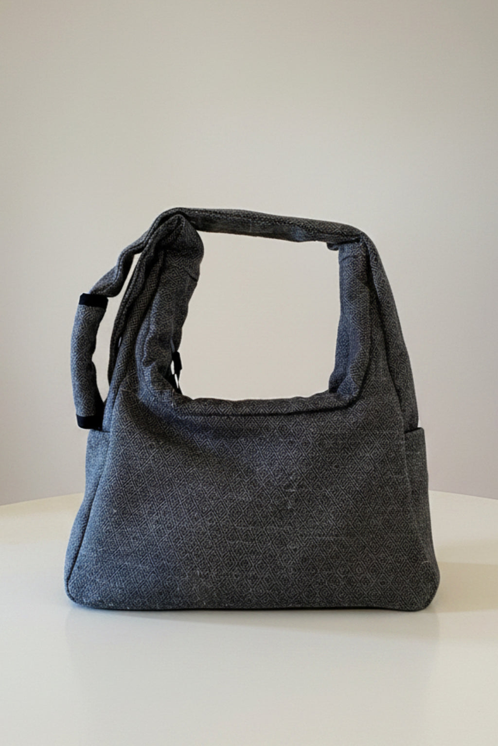 Stacy Stewart Smith's Men's Diamond Dodger Trapezoid messenger bag in Cement/Onyx back view showing zip pocket and divider against a gray background.