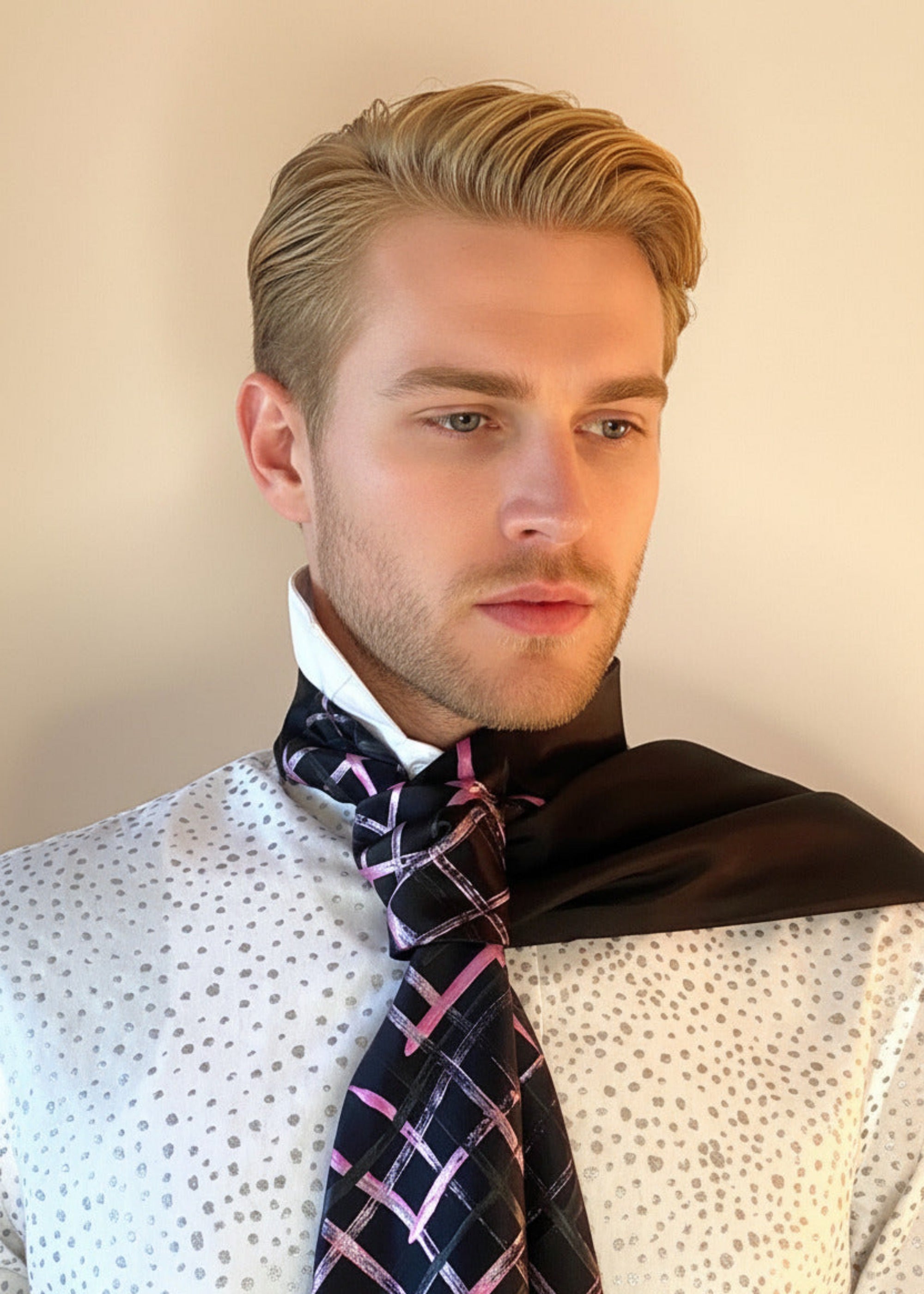 HOW TO TIE A CRAVAT: STEP 5 Atelier Quarterly presents Stacy Stewart Smith's Hand-Painted Cotton Percale Shirt and Hand-Painted Silk Cravat in Onyx/Shocking on a male mannequin front view with collar up against an ivory backdrop.