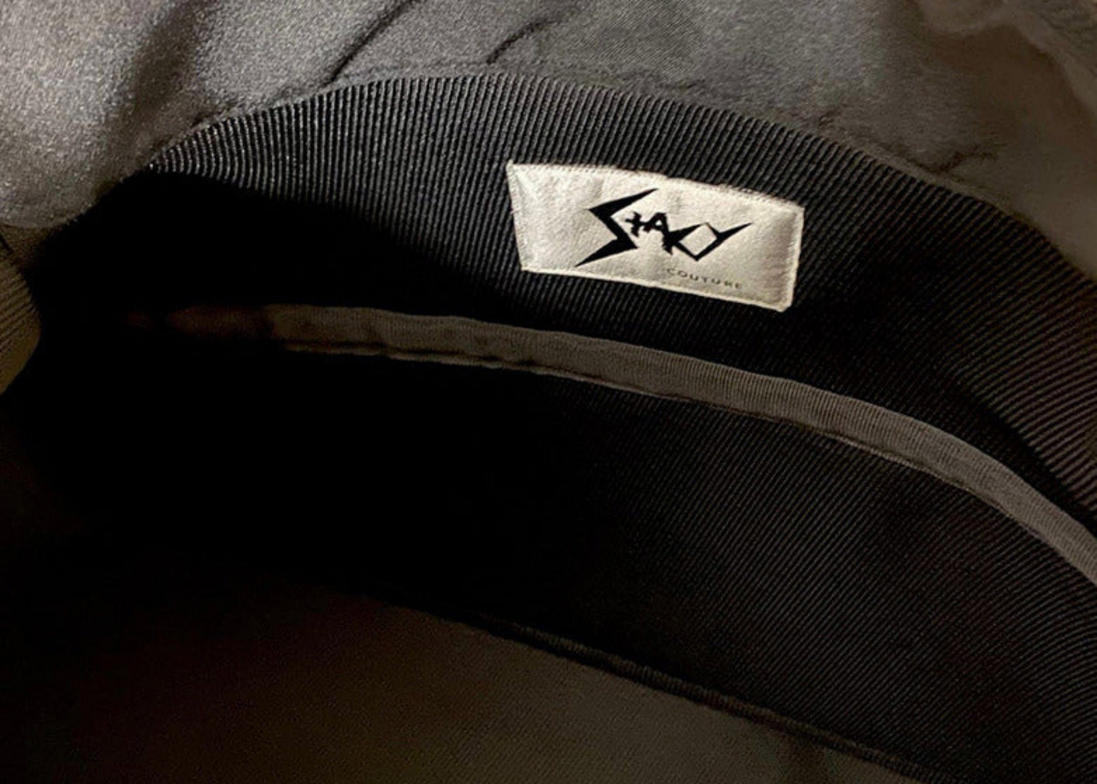 Stacy Stewart Smith Trapezoid Leather Messenger Bag in Onyx view of lining folder pocket Stacy Couture brand label.