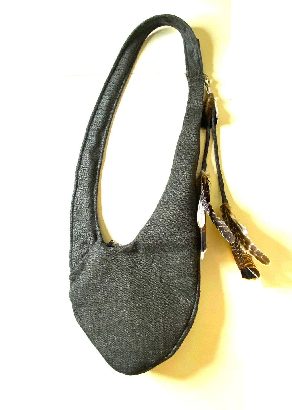 Stacy Stewart Smith Men's Diamond Dodger Tweed Newsie Sling Bag on male model back view flat on an ivory surface.