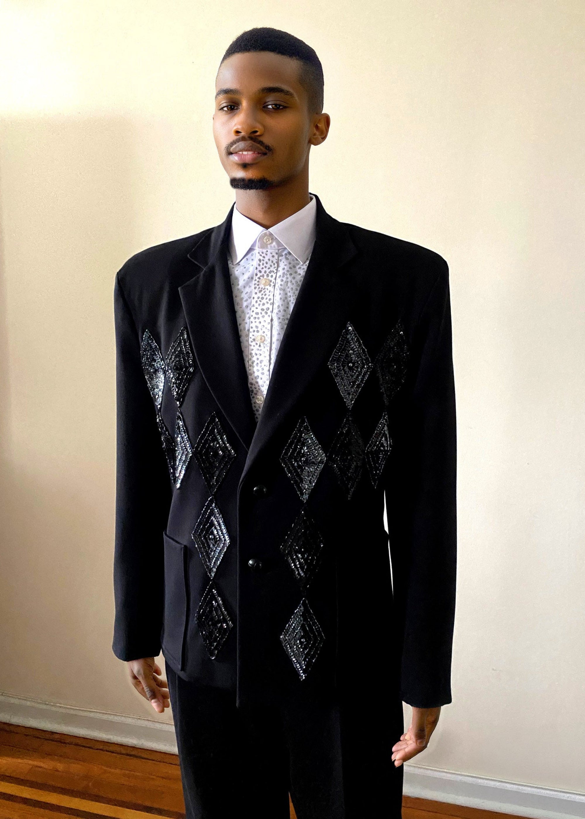 Stacy Stewart Smith Men's Black Knit, Sequin and Beaded Harlequin Blazer on mannequin 6'3" front view in room with wood floor and against antique white wall.