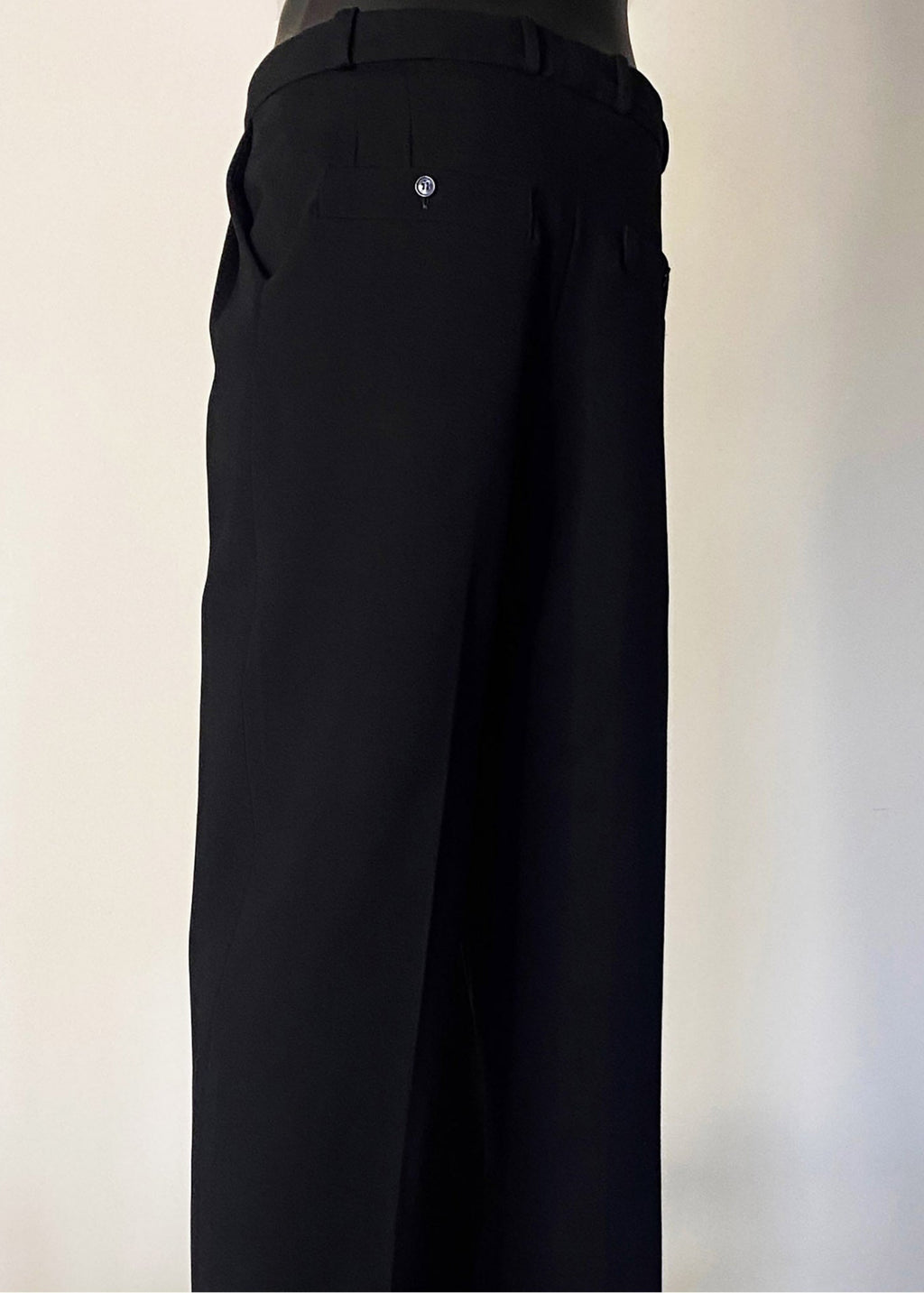 Stacy Stewart Smith Men's Black Knit Pleated Windsor Pants on mannequin 6'3" 3/4 back view with ivory backdrop. 