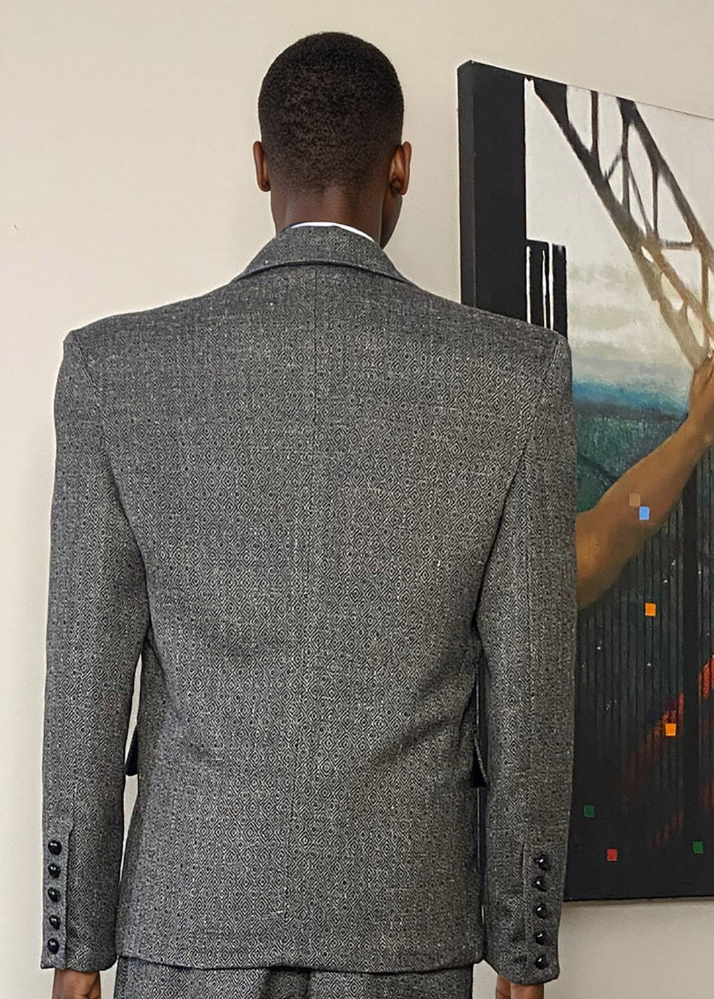 Stacy Stewart Smith Men's Diamond Dodger Tweed Notched Lapel Blazer on a mannequin 6'3" (back view) against an Antique White wall with a Stacy Stewart Smith oil painting hanging.