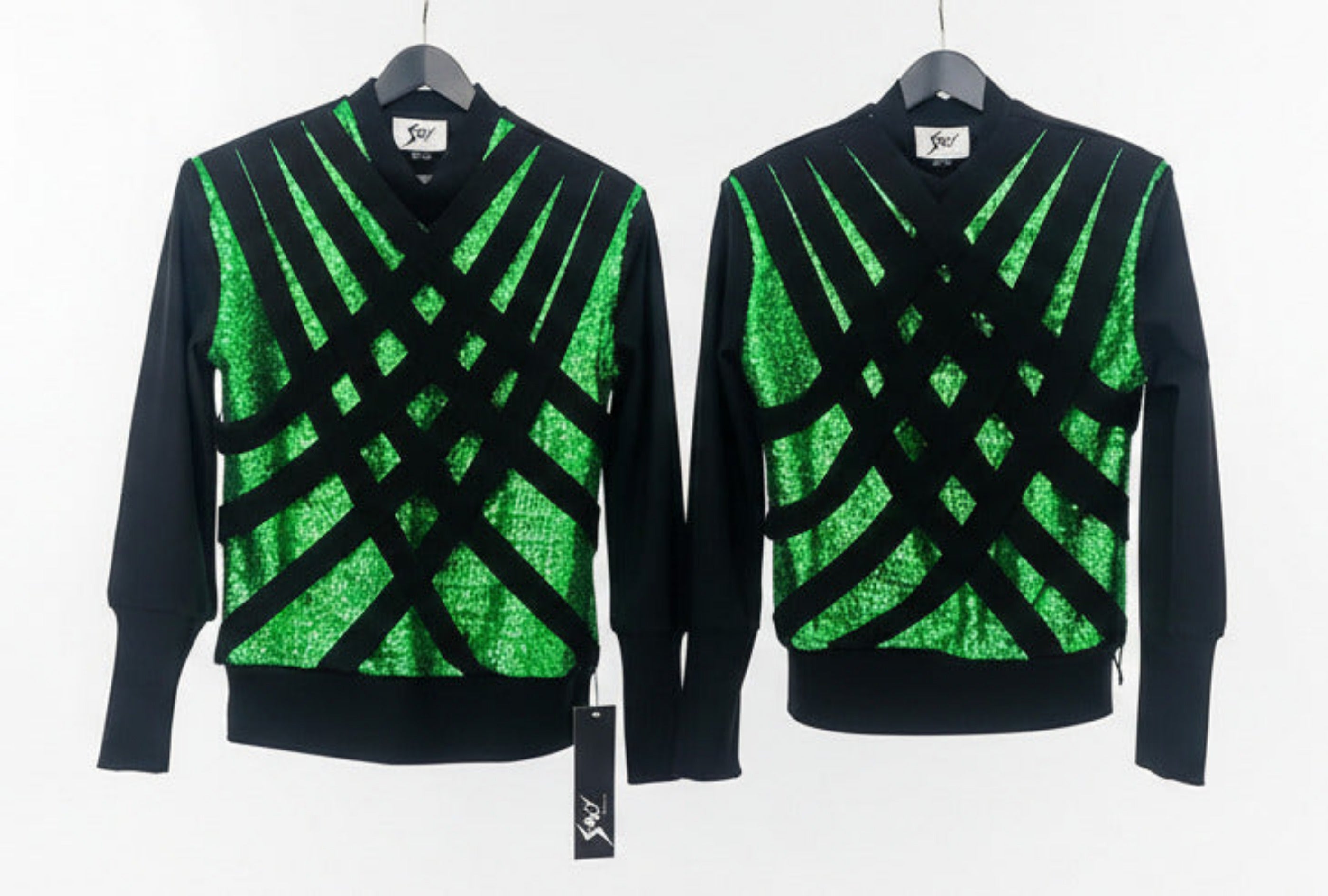 Two Stacy Stewart Smith Argyle Labyrinth tops with Peridot sequins beneath strategically placed bands to create spacial geometric shapes on hangers against a white background.