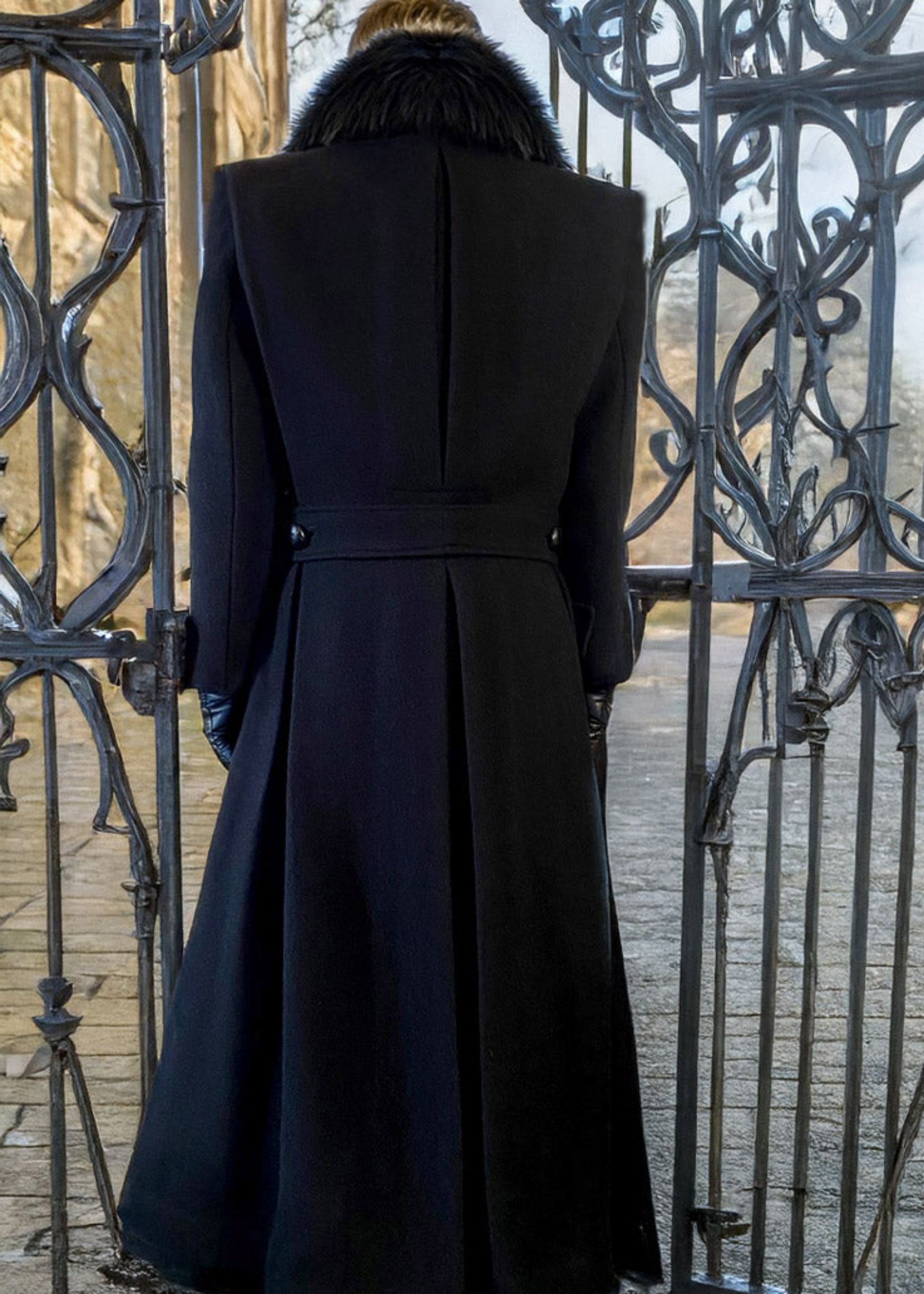 Stacy Stewart Smith Men's Harris Tweed Wool Processional Great Coat on mannequin 6'3" back view in front of a gate n England. 