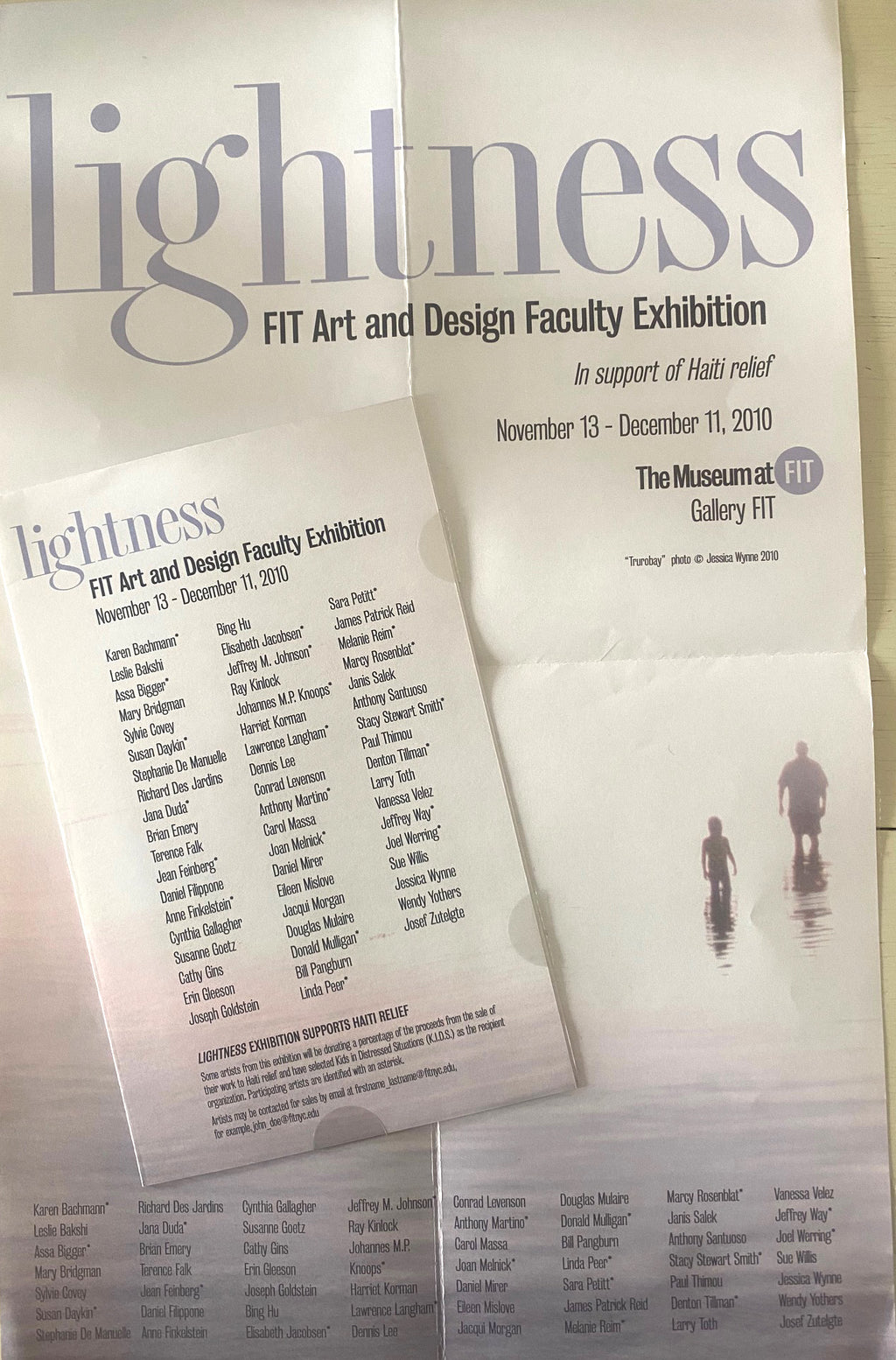 Two printed exhibition posters for the Lightness FIT Art and Design Faculty Exhibition at the Museum at FIT Gallery, one larger and one smaller overlapping in front, photographed on a white surface. Stacy Stewart Smith's name appears as an exhibiting artist.